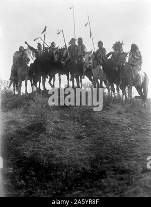 Fotodruck von acht Crow-Indianer zu Pferd, Silhouette auf Hügel. Fotografiert von Curtis (1868 – 1952), US-amerikanischer Ethnologe und Fotograf des amerikanischen Westens und der indianischen Völker. Datiert 1908 Stockfoto