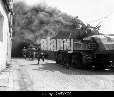 Foto des M4 Sherman-Panzer bewegen durch einen Rauch gefüllten Straße in Wernberg, Deutschland. Datiert 1943 Stockfoto