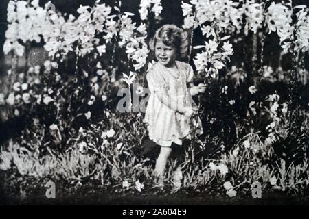 Foto von einer jungen Prinzessin Elizabeth (1926-) die ältere Schwester von Prinzessin Margaret (1930-2002) und zukünftige Königin unter den Blumen spielen. Vom 20. Jahrhundert Stockfoto