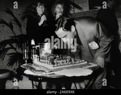 Französische TV-Moderatorin Thierry Ardisson feiert seinen Geburtstag mit einem Kuchen mit dem Bildnis seiner Show "Bains de Minuit". Hinter ihm: Marie-France Brière und Catherine Barma. Januar 5, 1988 Stockfoto