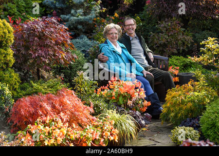 Rentnerehepaar Marie und Tony Newton in Ihren vier Jahreszeiten Garten als es in herbstlichen Farben platzt an ihrem Haus in Walsall, West Midlands. Stockfoto