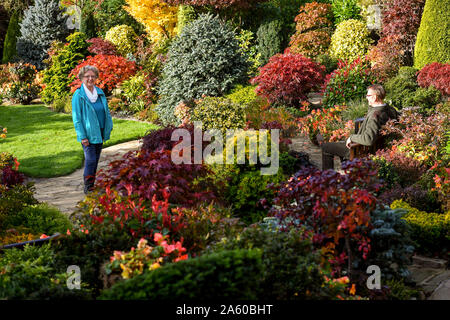 Rentnerehepaar Marie und Tony Newton in Ihren vier Jahreszeiten Garten als es in herbstlichen Farben platzt an ihrem Haus in Walsall, West Midlands. Stockfoto