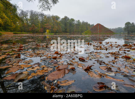 Cottbus, Deutschland. 23 Okt, 2019. Blick auf die herbstliche See Pyramide im Fürst-Pückler-Park Branitz. Wilder Wein wächst auf der Pyramide, die Blätter nur herbstliche gedreht haben. Auf dem Wasser die Blätter der Buche stehen am Ufer schwimmen. Der Park, der sich mit großer Sensibilität von Hermann Fürst von Pückler-Muskau in Branitz, gilt als der letzte der großen deutschen Landschaftsgarten. Foto: Patrick Pleul/dpa-Zentralbild/ZB/dpa/Alamy leben Nachrichten Stockfoto