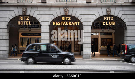 Oktober 2019. Black Cab Taxi vorbei das Ritz Hotel in Piccadilly, London, UK während der morgendlichen Rush-hour. Stockfoto