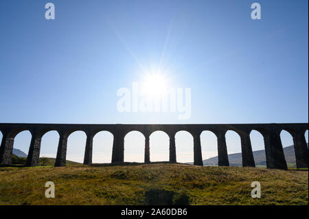 Ein Sommer Sonne in einem blauen Himmel über Ribblehead Viadukt über die Carlisle Railway Line, North Yorkshire niederzulassen. Stockfoto