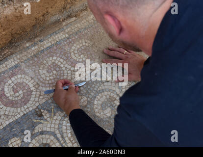 Ramat Beit Shemesh, Israel. 23 Okt, 2019. Ein Arbeitnehmer, der Israel Antiquities Authority reinigt ein Mosaik auf dem Boden einer 1500 Jahre alten byzantinischen Kirche in Ramat Beit Shemesh, am Mittwoch, 23. Oktober 2019. Die drei Jahre Ausgrabungen entdeckt die Kirche, griechische Inschriften, Mosaiken, eine Taufe und eine Krypta eines unbekannten glorreichen Märtyrer. Foto von Debbie Hill/UPI Quelle: UPI/Alamy leben Nachrichten Stockfoto