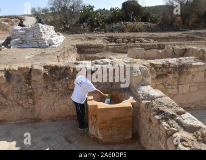 Ramat Beit Shemesh, Israel. 23 Okt, 2019. Ein Arbeitnehmer, der von der Israel Antiquities Authority reinigt ein Taufbecken in der Form eines Kreuzes, in einer Ausgegrabenen 1.500 Jahre alten byzantinischen Kirche in Ramat Beit Shemesh, am Mittwoch, 23. Oktober 2019. Die drei Jahre Ausgrabungen entdeckt die Kirche, griechische Inschriften, Mosaiken, eine Taufe und eine Krypta eines unbekannten glorreichen Märtyrer. Foto von Debbie Hill/UPI Quelle: UPI/Alamy leben Nachrichten Stockfoto