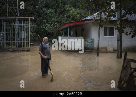 Welle, Gilan, Iran. 22 Okt, 2019. Ein Mann steht in der Regen an seinem lichtdurchfluteten Haus. Schwere Regenfälle zu Erdrutschen und Überschwemmungen in die Welle Stadt. Mehrere Brücken eingestürzt und Straßen der drei hundert Haushalte des Dorfes Visrood blockiert waren. Die Flut beschädigt auch Häuser und Farmen. Welle ist eine Stadt im Westen der Provinz Guilan. Credit: Babak Jeddi/SOPA Images/ZUMA Draht/Alamy leben Nachrichten Stockfoto