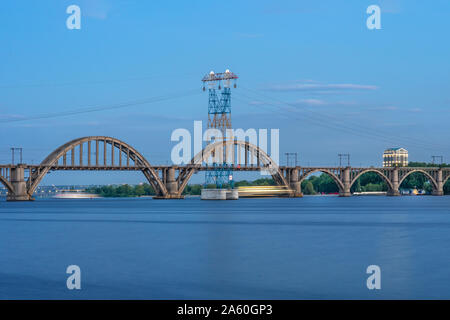 Die malerische Landschaft der Ukrainische Dnipro Stadt mit alten arch Eisenbahn Merefo-Kherson Brücke über den Fluss Dniepr in Dnipropetrowsk, Ukraine. Sun Stockfoto