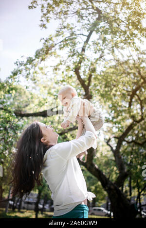 Glückliche Mutter Spaß mit Ihren baby boy im Park Stockfoto