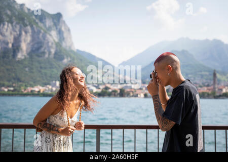 Junger Mann, Foto von seiner Freundin vor Lake Como, Lecco, Italien Stockfoto