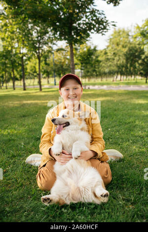Junge mit Welsh Corgi Pembroke in einem Park Stockfoto