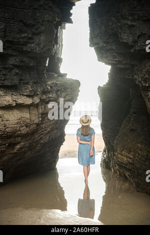 Frau stehend auf Kathedralen Strand mit Felsen, Rückansicht, Galizien, Spanien Stockfoto