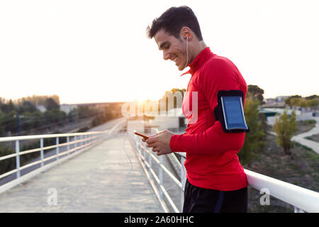 Jogger mit Smartphone im Arm Pocket Stockfoto