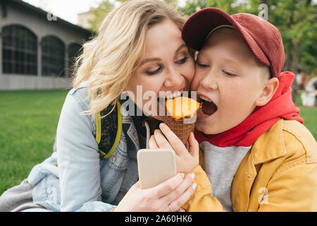 Mutter und Sohn gemeinsam Eis essen Stockfoto