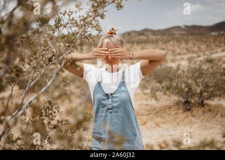 Junge Frau, die in der Wüste Landschaft, Joshua Tree National Park, Kalifornien, USA Stockfoto