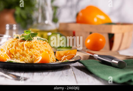 Gekochten Reis mit Karotten und Paprika auf dem Küchentisch Stockfoto