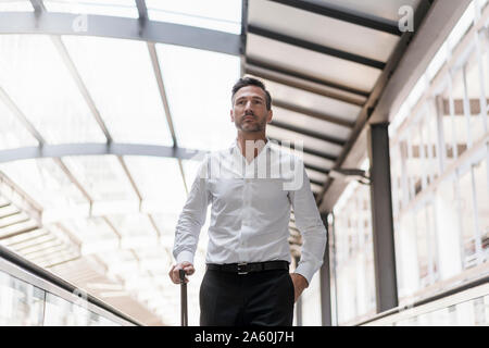 Geschäftsmann auf fahrsteig am Flughafen Stockfoto