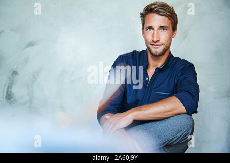 Portrait von selbstbewussten jungen Mann sitzen Stockfoto