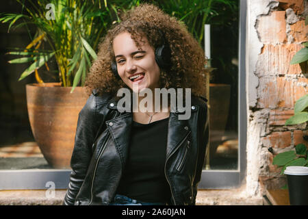 Portrait von jugendmädchen Musik hören mit Kopfhörern heraus haften Zunge Stockfoto