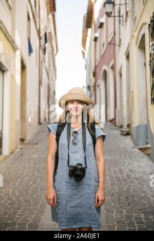 Portrait von Frau mit Kamera in einer Gasse in der Altstadt von Coimbra, Portugal Stockfoto