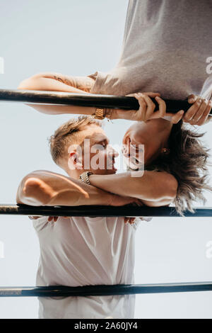 Junges Paar küssen einander auf einem Klettergerüst Stockfoto
