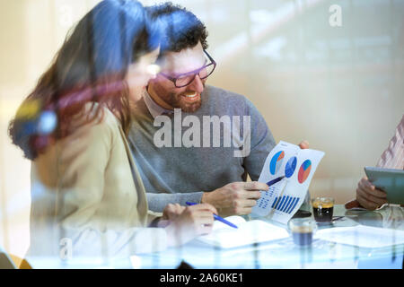 Drei Personen in einem Meeting in modernen Büro teilen Grafiken Stockfoto