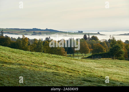 Ein Blick von Crieff Hydro Lodges auf ein Nachbarfeld in einem frühen Morgennebel im Tal. Stockfoto