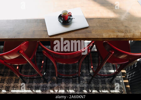 Laptop und eine Tasse Kaffee in einem Café auf Tisch Stockfoto