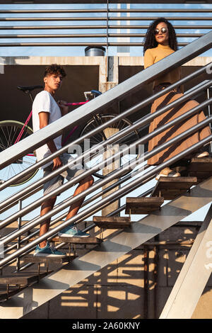 Junges Paar beim Treppensteigen, Fahrradverleih, Durchführung Stockfoto