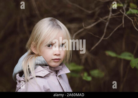 Portrait von starren kleines Mädchen im Wald Stockfoto