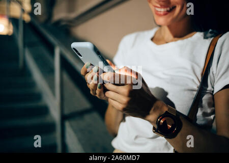 Junge Frau mit Smartphone in die Stadt bei Nacht Stockfoto