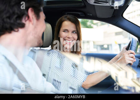 Glückliches Paar in einem Auto mit Frau fahren Stockfoto