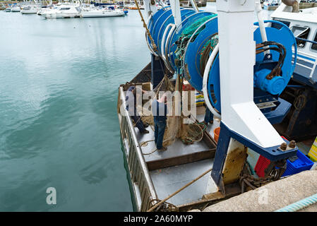 Saint-Vaast-la-Hougue, der Manche/Frankreich - 16. August 2019: fischer Reparatur Fischernetze auf dem Fischerboot im Hafen Stockfoto