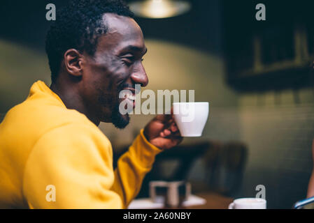 Laughing man bei einer Tasse Kaffee in einem Café Stockfoto