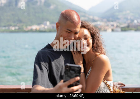 Portrait von glückliches junges Paar unter selfie vor Lake Como, Lecco, Italien Stockfoto