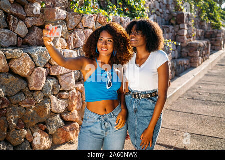 Porträt von zwei jungen Frauen, die selfie mit Smartphone Stockfoto