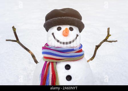 Porträt einer niedlichen Schneemann mit einem freundlichen Lächeln auf dem Hintergrund der weißen Schnee. Traditionelle winter Charakter Stockfoto