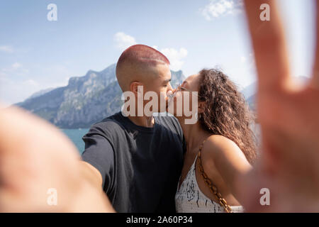 Junges Paar unter selfie während Küssen, Lecco, Italien Stockfoto