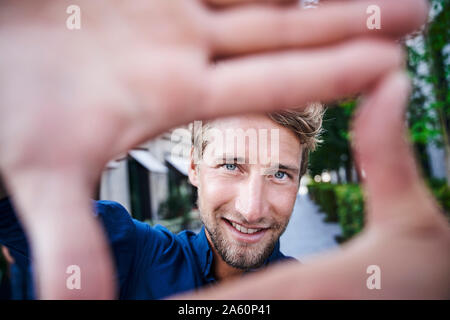 Portrait von selbstbewussten jungen Mann, der einen Finger frame Stockfoto