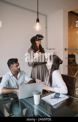 Kolleginnen und Kollegen im Büro testen VR-Simulator Stockfoto