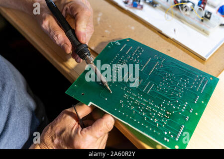 Ältere Menschen arbeiten an elektronischen Schaltungen in seiner Werkstatt, in der Nähe Stockfoto