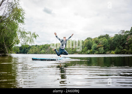 Unternehmer springen von SUP-Boards in einem See Stockfoto