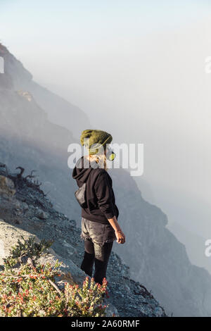 Junge Frau mit beatmungsmaske stehen am Rande des Vulkans Ijen, Java, Indonesien Stockfoto