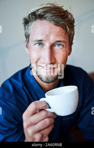 Porträt des jungen Mannes mit Tasse Kaffee Stockfoto