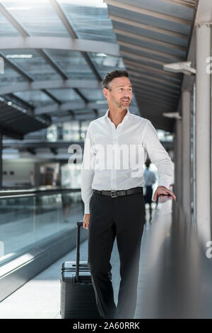 Geschäftsmann auf fahrsteig am Flughafen Stockfoto