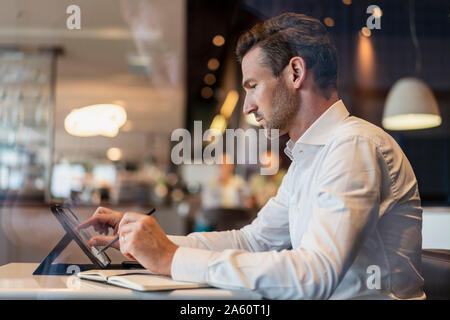 Mit Tablet und Notizen in einem Cafe Geschäftsmann Stockfoto