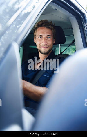 Portrait von selbstbewussten jungen Mann im Auto. Stockfoto