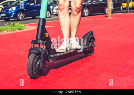 Beine der jungen Frau reiten E-Scooter auf dem Boulevard der Stars, Berlin, Deutschland Stockfoto