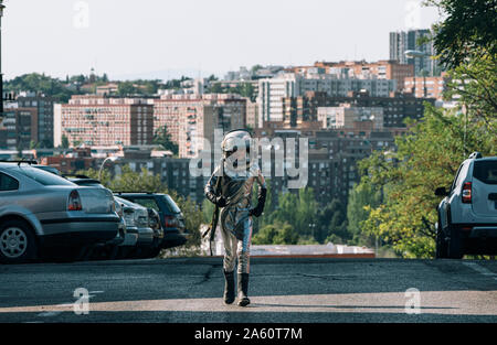 Junge gekleidet wie ein Astronaut zu Fuß auf einer Straße in der Stadt Stockfoto